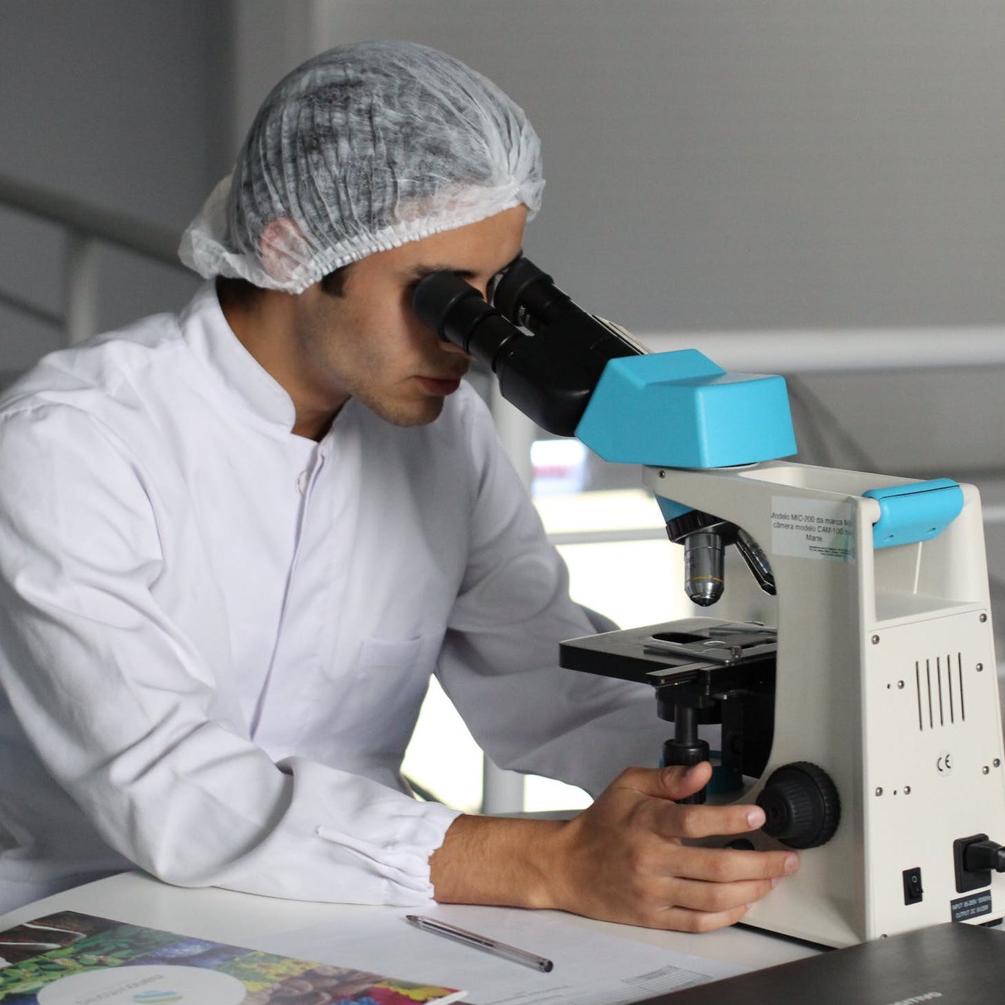 Lab technician looking through microscope